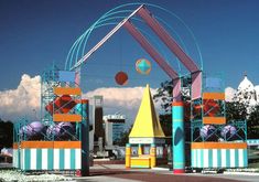 the entrance to an amusement park is decorated with colorful structures and balloons in blue, orange, yellow, and pink