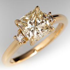 a yellow gold ring with a princess cut diamond