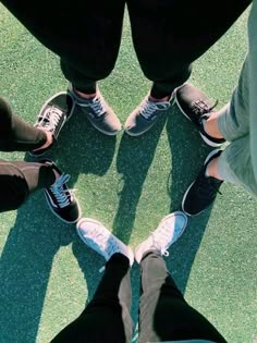 four people standing in a circle with their feet on the ground