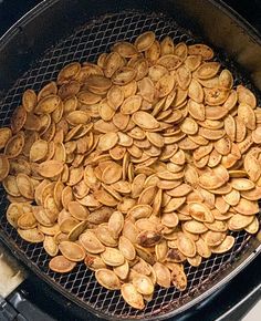 a pile of pumpkin seeds sitting in an air fryer