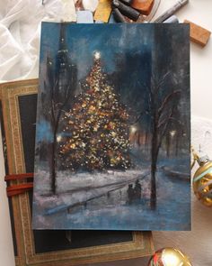 a painting of a christmas tree on a table next to other art supplies and decorations