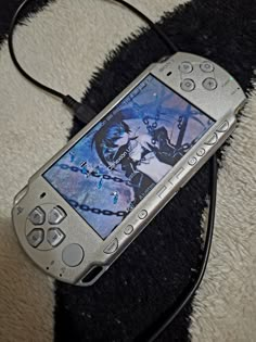 a cell phone laying on top of a black and white rug next to a charger