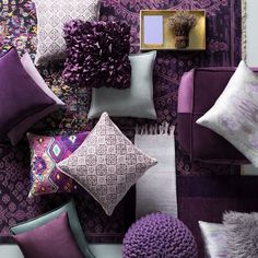 purple and white pillows are arranged on the wall