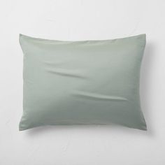 a light green pillow sitting on top of a white wall