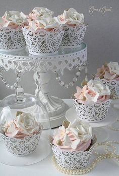 there are many cupcakes that are on the cake platter, and one is decorated with pink roses