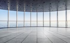 an empty room with floor to ceiling windows overlooking cityscape and skyscrapers in the distance