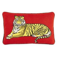 a red pillow with a yellow tiger sitting on it's back and eyes closed