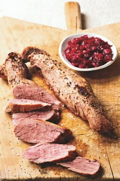 meat and cranberry sauce on a cutting board