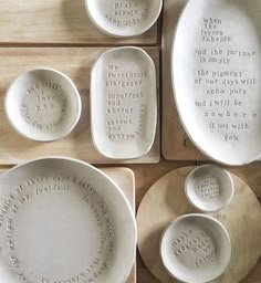 white dishes with words written on them sitting on wooden boards