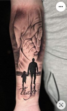 a man with a tattoo on his arm holding the hand of a child