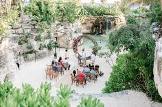 a group of people sitting at tables in front of a waterfall