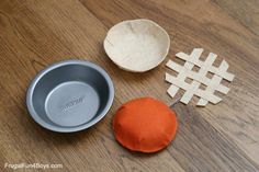 an orange and white object sitting on top of a wooden table next to a metal bowl