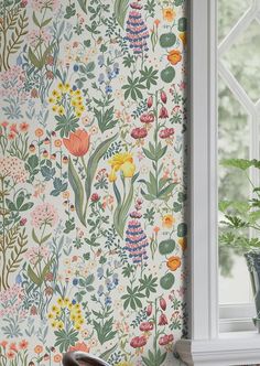 the wall paper is very colorful and has flowers on it, as well as plants