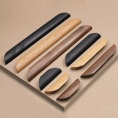 an assortment of wooden spoons and spatulas arranged on a table with a beige background