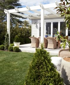 an outdoor living area with chairs and plants