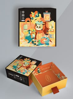 an open box with the lid opened next to it on a gray surface, and another box that is decorated with cartoon characters