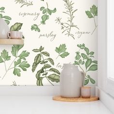 the wallpaper in this kitchen is painted with green leaves and words that spell their name