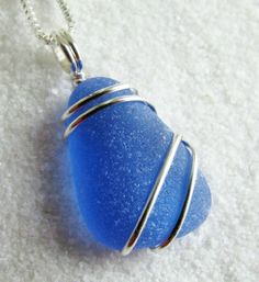 a blue sea glass pendant on a silver chain