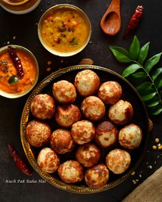 some food that is in a bowl on a table with spoons and sauces