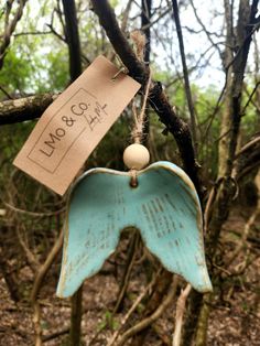 an angel ornament hanging from a tree branch with a price tag on it