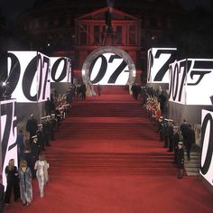 people are walking down the red carpeted stairs in front of large letters that read 007