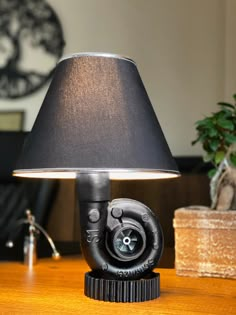 a lamp that is sitting on top of a table next to a potted plant