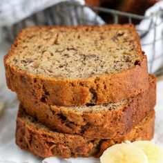 three slices of banana bread stacked on top of each other next to some sliced bananas