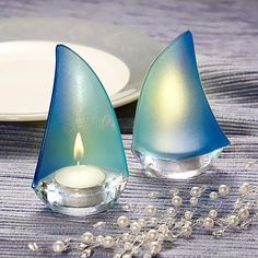 two blue glass candlesticks sitting on top of a table next to a plate