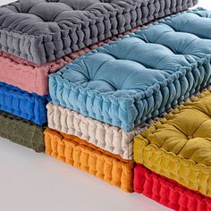 four different colors of pillows stacked on top of each other in the shape of a rectangle