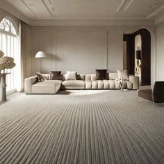 a large living room with white walls and beige carpeted flooring, along with an l - shaped sectional sofa