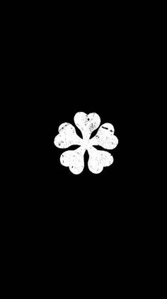 a black and white photo of a four - leafed clover on a dark background