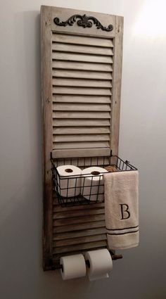 an old shuttered window is used as a towel rack for toilet paper and towels