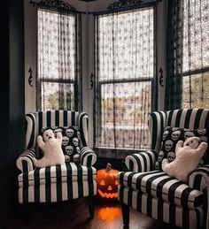 two black and white striped chairs in front of windows with halloween decorations on the floor