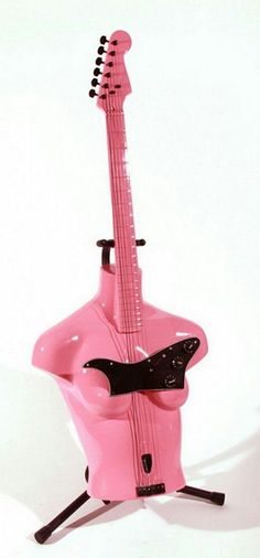 a pink guitar sitting on top of a stand