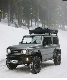 an suv is parked in the snow with a roof rack on it's top