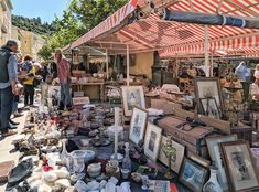 an outdoor flea market with people looking at items