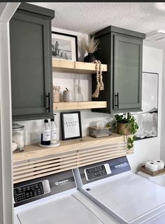 a washer and dryer in a laundry room with cabinets above the washer