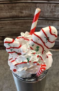 a glass filled with whipped cream and candy cane