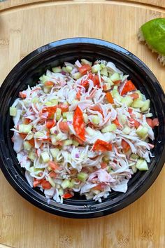 a bowl filled with coleslaw and carrots on top of a wooden cutting board