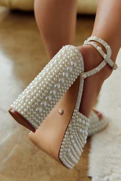 a close up of a person's shoes with pearls on the toes and heels