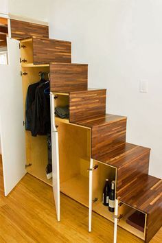 an open closet under some stairs in a room