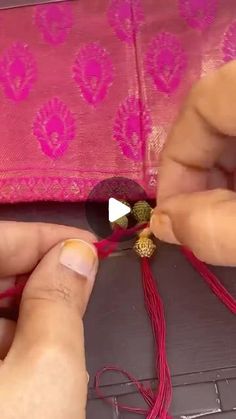 someone is working on something that looks like an ornament with beads and thread