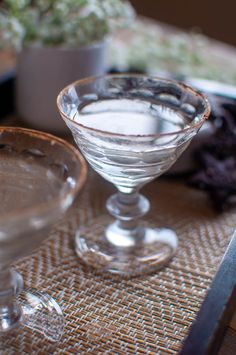 two martini glasses sitting next to each other on a table