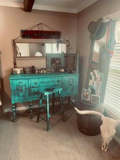 a room with two stools and a dresser in the corner, along with a cow skull on the floor