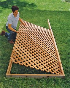 a man kneeling down next to a wooden structure