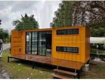 a small yellow building sitting on the side of a road