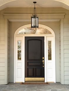 a black front door with a potted plant on the side