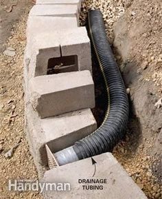 a drainage pipe is connected to the side of a concrete block wall with pipes running through it