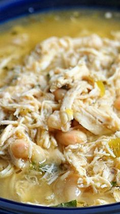 a blue bowl filled with chicken and beans soup