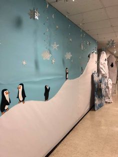 an office hallway decorated with penguins and snowflakes on the wall, as well as decorations